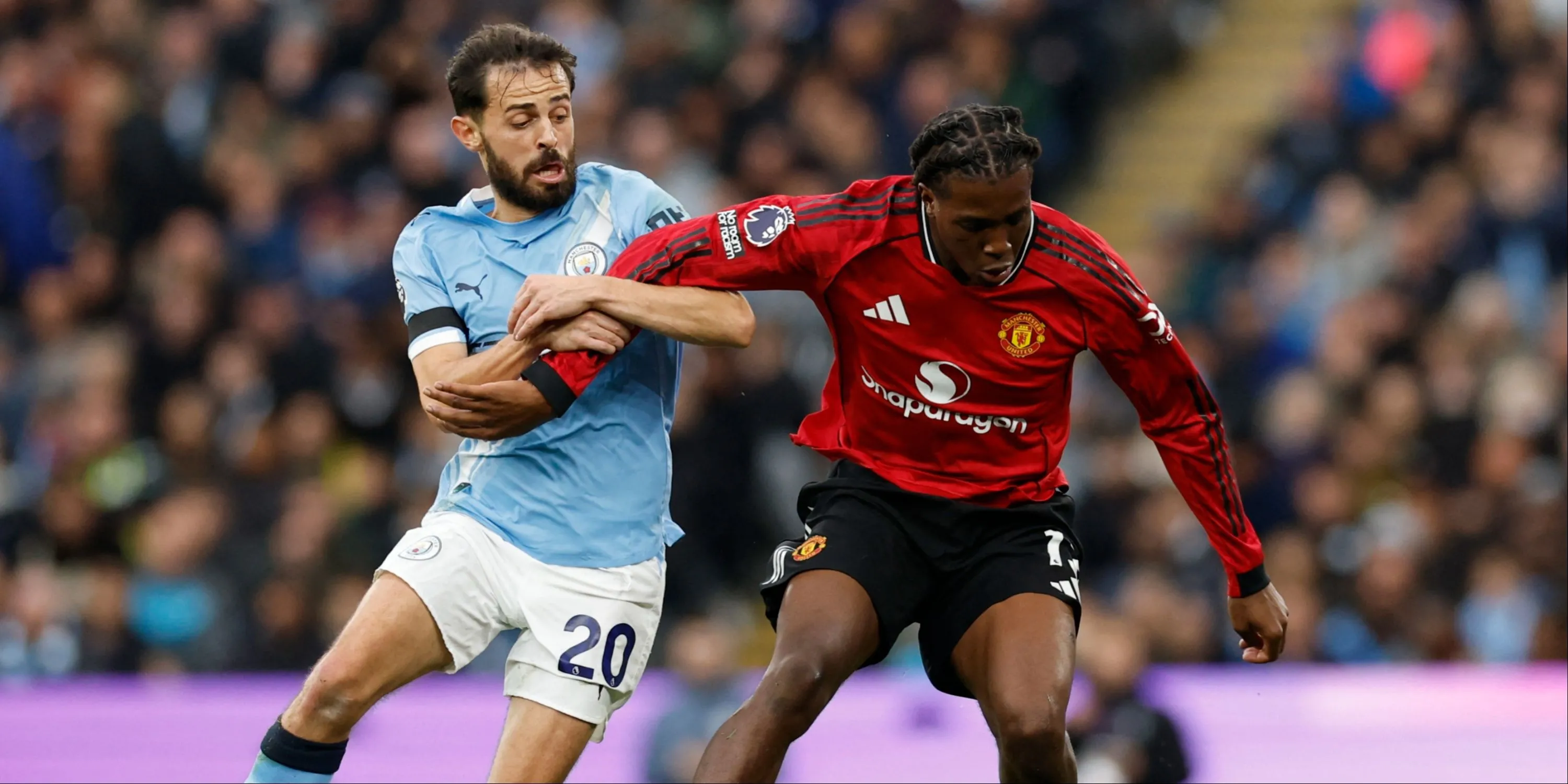 Patrick Dorgu trong một pha tranh chấp với Bernardo Silva